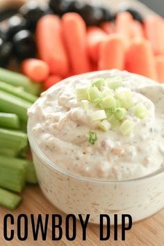 a bowl of dip surrounded by celery and carrots