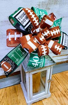 a football themed bow on top of a small stand with other items around it,