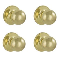 four brass door knobs on a white background