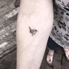 a small bird tattoo on the leg