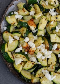 a pizza topped with zucchini and feta cheese