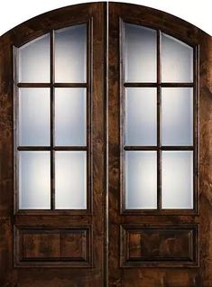 an arched wooden door with frosted glass on the top and side panels, in dark wood