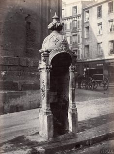 an old black and white photo of a man standing at the entrance to a building