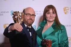 a man and woman pose with an award for best performance in a musical at the british academy awards