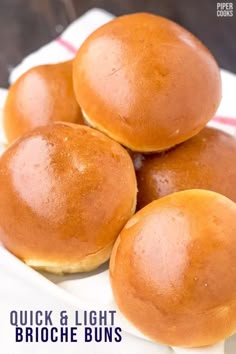 three buns sitting on top of a white plate next to a red and white napkin