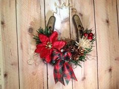 a christmas wreath hanging on the side of a wooden wall with pine cones and poinsettis