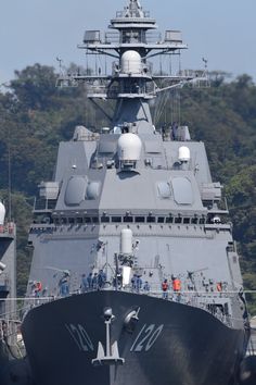 a large gray ship is docked in the water