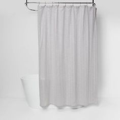 a white shower curtain next to a toilet