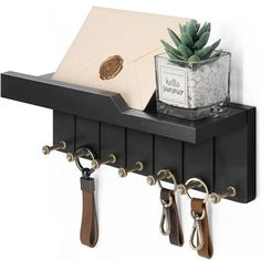 a shelf with keys and other items hanging on it's sides, along with a potted plant