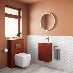 a white toilet sitting next to a bathroom sink under a round mirror on a wall