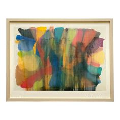 an abstract painting with multicolored paint on white paper in a wooden framed frame