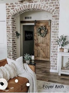 a living room filled with furniture and a wooden door in the middle of a brick wall