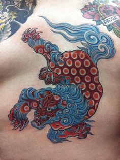 a man with tattoos on his chest has a dragon tattoo on it's back