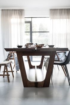 a dining room table with chairs and a window in the backgroung area