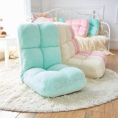 two different colored chairs sitting on top of a rug