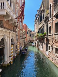 a narrow canal in venice, italy surrounded by buildings