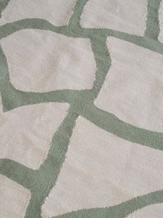 an area rug with green and white designs on it's edges, including squares