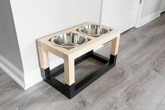 a wooden table with two metal bowls on it