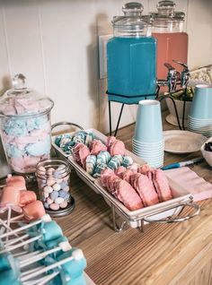 a table topped with lots of candy next to blue jars and containers filled with candies