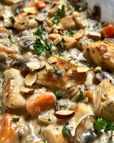 chicken and mushroom soup with carrots, parsley and almonds in a white bowl