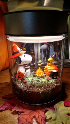 a glass jar filled with halloween decorations on top of a table