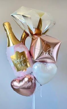 a bouquet of balloons that say bride to be and champagne bottles with gold foil wrapped around them