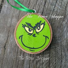 a green ornament with an angry grin face on it's front and side