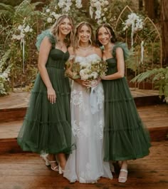 three bridesmaids in green dresses posing for the camera