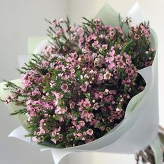 a bouquet of pink flowers wrapped in white paper