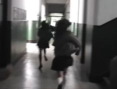 blurry photograph of two people walking down a hallway