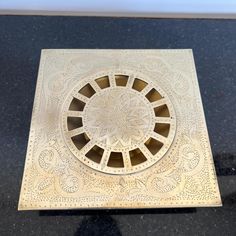 an intricately designed metal object on a black surface