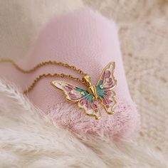 Indulge in the enchanting allure of this Pastel Enameled Butterfly Necklace, meticulously crafted to capture the whimsical essence of fairy realms and the grace of fairy princesses. This exquisite necklace features a delicately enameled butterfly pendant (size 18x25mm), made of 24k gold plated brass, suspended from a 14k gold plated stainless steel chain. Elina butterfly necklace is carefully handcrafted, ensuring its exceptional quality. Embrace the magic of fairy realms with this exquisite nec Butterfly Charms Necklace For Gift, Whimsical Handmade Butterfly Necklace, Handmade Whimsical Butterfly Necklace, Fairycore Butterfly Necklace As A Gift, Fairycore Butterfly Necklace For Gift, Fairycore Butterfly Necklace Gift, Fairycore Jewelry With Butterfly Charm For Gifts, Fairy Style Gold Jewelry For Gift, Whimsical Gold Necklace For Gifts