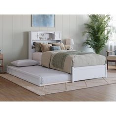 a white bed sitting on top of a wooden floor