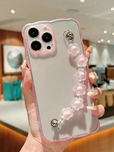 a person holding up a phone case with pearls