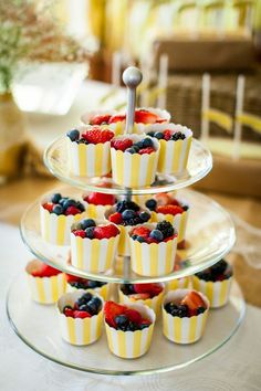 cupcakes with berries and blueberries are stacked on top of each other