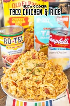 a plate full of taco chicken and rice on a table with cans of food in the background