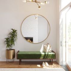 a living room with a couch, mirror and potted plant on the floor in front of it