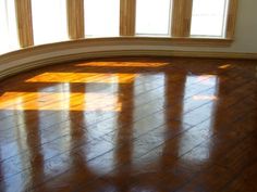 an empty room with wooden floors and windows