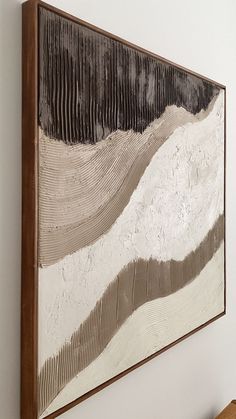 a painting hanging on the wall above a wooden bench