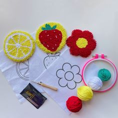 crocheted fruit and vegetables on top of a white towel next to knitting supplies