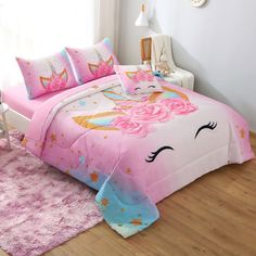 a bed with pink sheets and unicorns on it