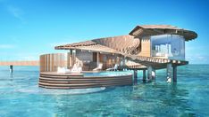 a house on stilts in the middle of the ocean with a pool and lounge area