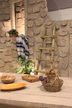 a table topped with plates and bowls next to a stone wall