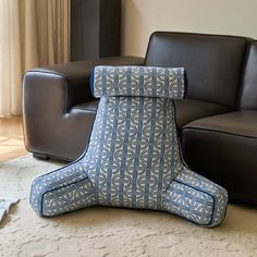 a blue and white chair sitting on top of a rug next to a black couch