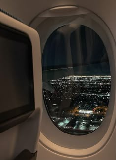 an airplane window looking out at the city lights