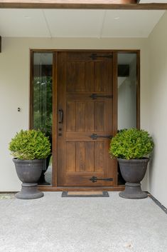 the front door to an american white ash ar4 exterior with two large planters