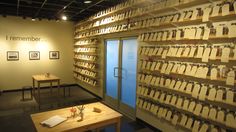 a room filled with lots of wooden tables and chairs next to a wall covered in memo notes