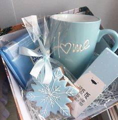 a blue coffee mug sitting on top of a table next to some cookies and other items