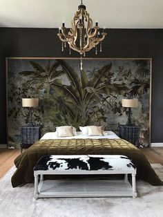 a bedroom with a bed, chandelier and paintings on the wall behind it