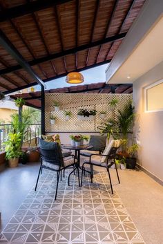 an outdoor patio with chairs, tables and potted plants